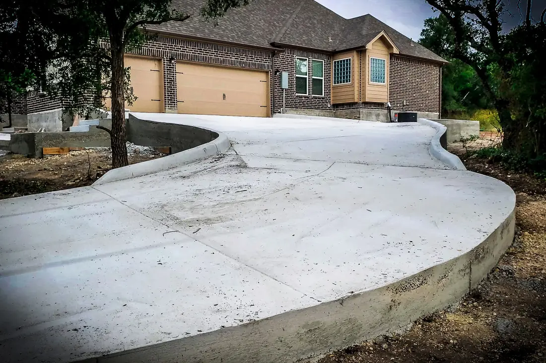 Circular concrete driveway and apron at a brick home in San Antonio