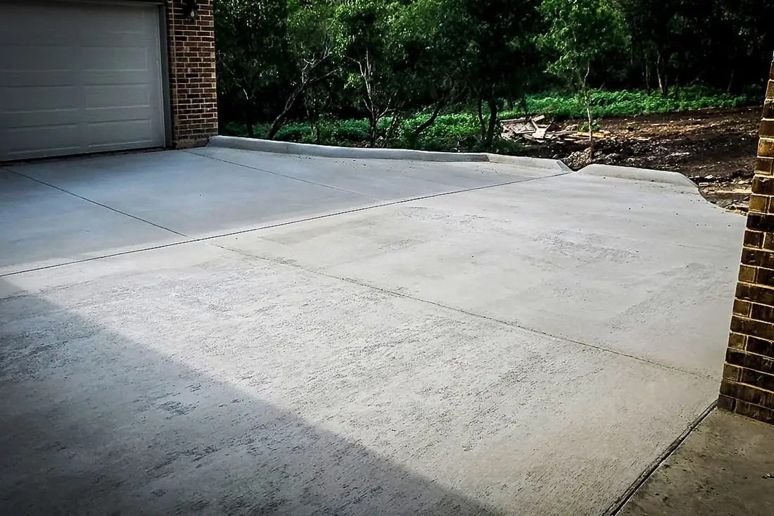 Concrete driveway apron poured up to a garage door in San Antonio