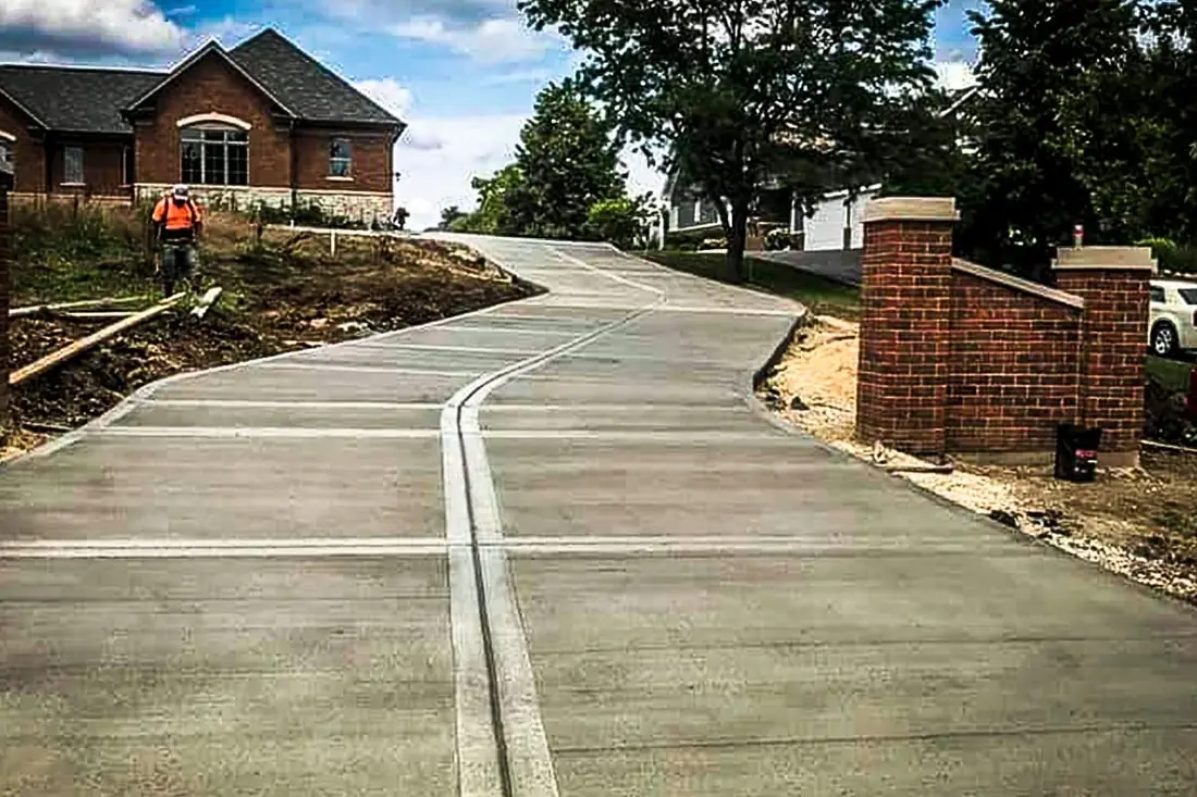 Concrete driveway running between brick entry columns near San Antonio