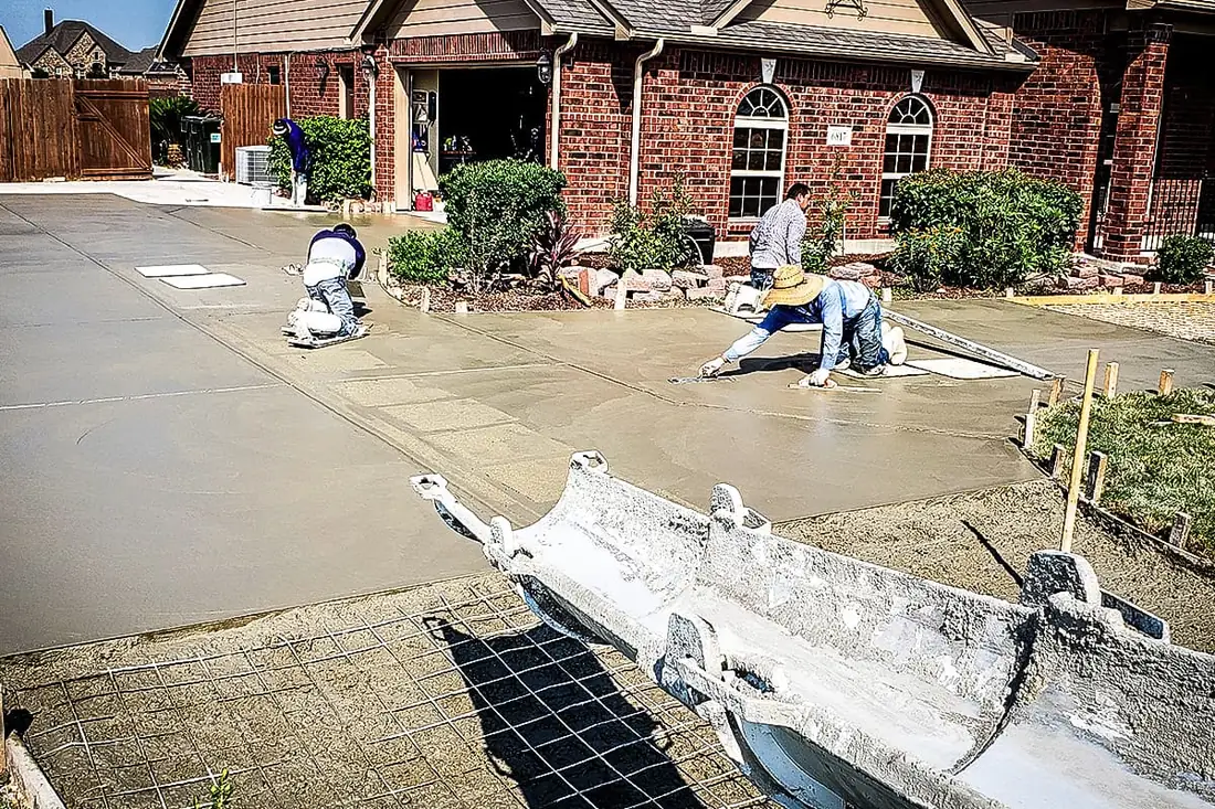 RL Concrete crew hand-finishing a wet concrete driveway in San Antonio