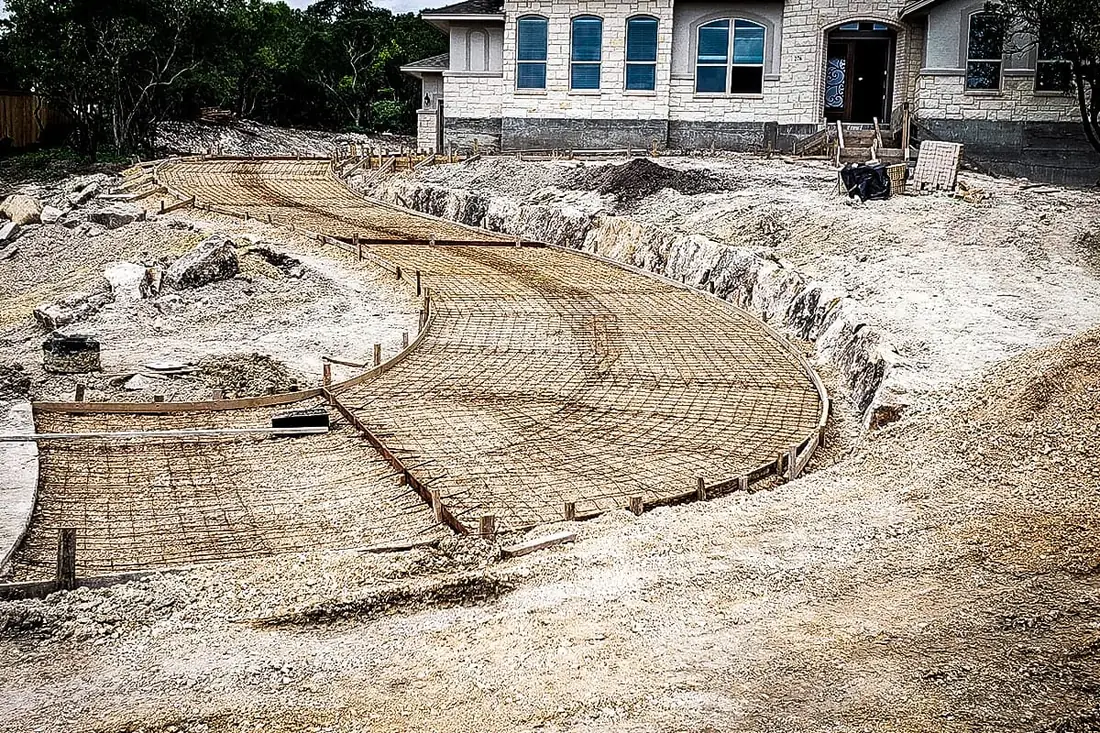 Steel reinforcement laid out for a sweeping concrete driveway near San Antonio