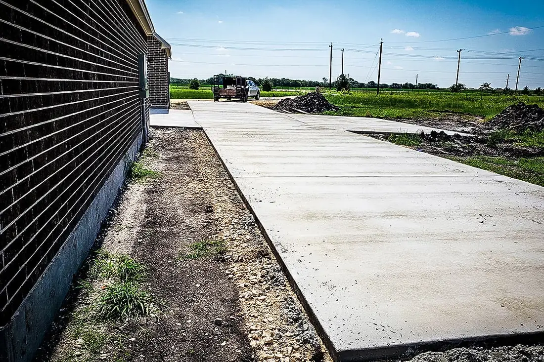 Wide concrete slab poured along the side of a brick building near San Antonio