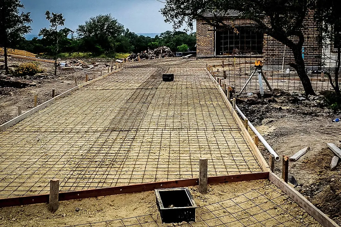 Rebar grid tied for a concrete slab beside a brick building near San Antonio