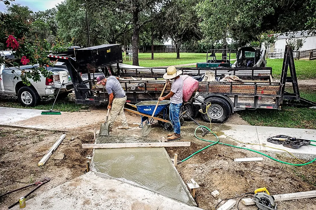 RL Concrete crew placing a concrete walkway section by wheelbarrow in San Antonio